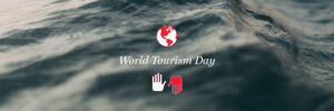 A globe and two hands, with the text "World Tourism Day" in front of a waving water